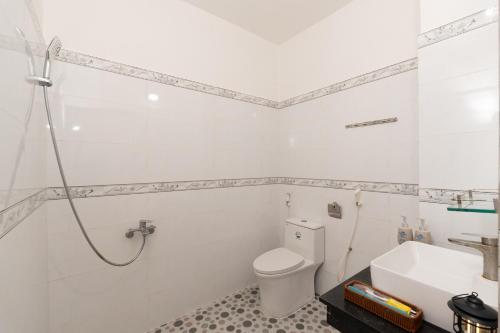 a white bathroom with a toilet and a sink at VitaSea Mui Ne homestay & pool in Mui Ne