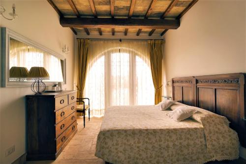 a bedroom with a bed and a large window at Agriturismo PIAN DEL GRANO Azienda agricola in Grotte di Castro
