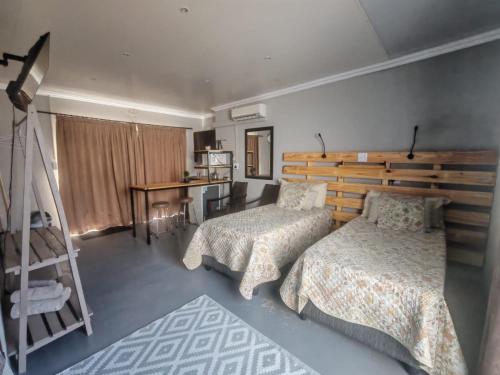 a bedroom with two beds and a ladder and a desk at ASAMé @ Oppi-Rivier in Christiana