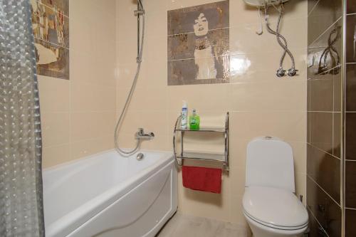 een badkamer met een wit toilet en een bad bij Kosmos Apartments on Morozova in Syktyvkar