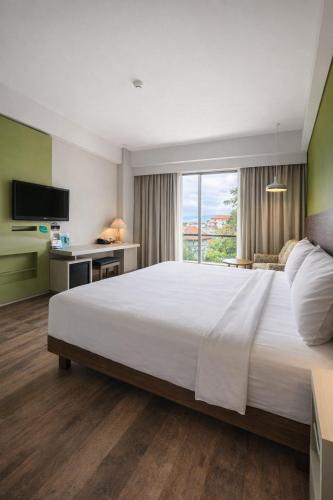 a bedroom with a large white bed and a window at Ion Bali Benoa in Nusa Dua