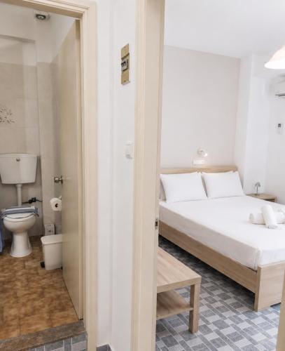 a bedroom with a white bed and a toilet at Soula Apartments & Studios in Palaiochora