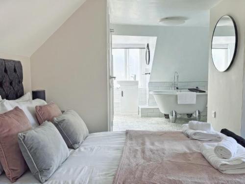 a bedroom with a large bed and a bath tub at Beaconsfield House in Mundesley