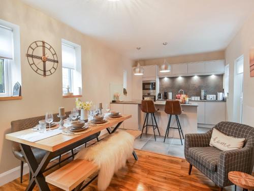a living room with a table and a kitchen at Beaconsfield House in Mundesley