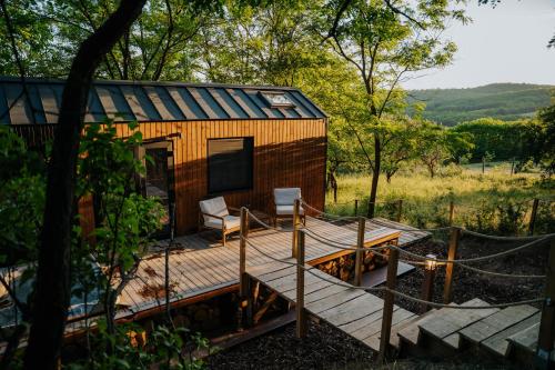 a wooden cabin with a porch and a deck at Feelmore Tiny House Karancsalja in Karancsalja