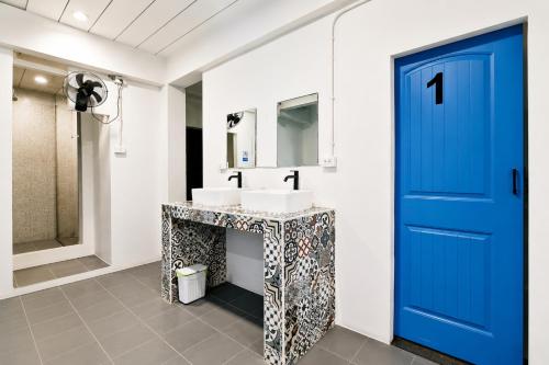 a bathroom with a blue door and a sink at Destiny Hostel Pattaya in Jomtien Beach