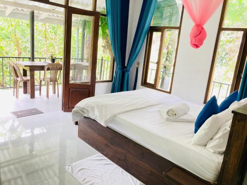 a bedroom with a bed with blue curtains and a table at Pepper Garden Ella in Ella