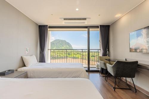 a hotel room with two beds and a balcony at Sanbangsan Hotel in Seogwipo