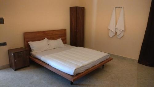 a bedroom with a large bed with a wooden headboard at Peony By Dhiya in Jadgenhalli