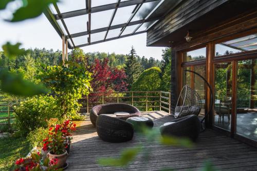 a wooden deck with chairs and flowers on it at Posestvo Laz - The Laz Estate in Voglarji