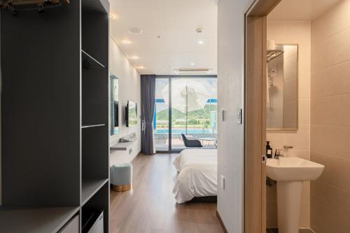 a bedroom with a bed and a sink and a bathroom at Sanbangsan Hotel in Seogwipo