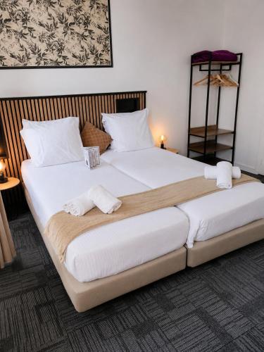 a large bed with two white towels on it at Le Lion dOr Hôtel de Charme et centre ville de Bernay in Bernay