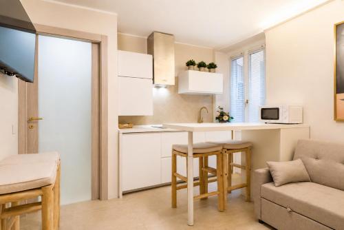 a small kitchen with a table and a couch at Lecco Antico Pozzo - Modern Suite in Lecco