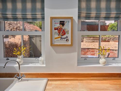 a kitchen with windows and a picture of a baseball player at 27 West Green in Newton Aycliffe
