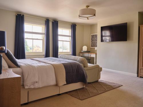 a bedroom with a bed and a chair and a television at 27 West Green in Newton Aycliffe