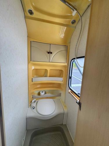 a small bathroom with a toilet in an airplane at Caravana dintre nuci in Oradea