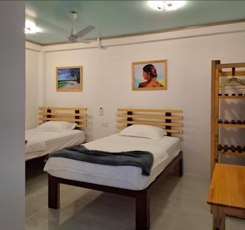 a bedroom with two beds and a ceiling at Gk Eleven in Himmafushi