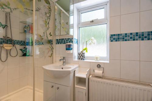 a bathroom with a sink and a window at K Suites - Liverpool Road Worcester with Hot Tub in Worcester