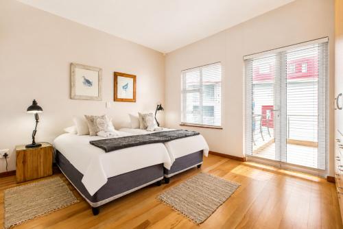 a bedroom with a large bed and two windows at Jetty Seaview Apartment in Swakopmund