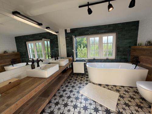 a large bathroom with four sinks and a tub at Wellness Chalet Luby in Luby