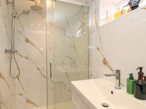 a bathroom with a shower and a sink at 8 Manor Villas in Totland