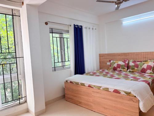 a bedroom with a bed and two windows at AeroNest Homes - 1BHK & 2BHK Quiet & Comfortable Near Airport 7km in Muthugadahalli