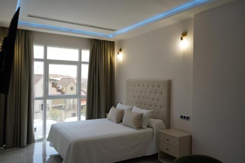 a bedroom with a white bed and a large window at HOTEL DON RAMIRO in Montilla