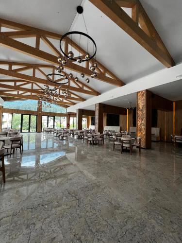 a large room with tables and chairs and a chandelier at Hotel Restaurant Splendor in Buşteni
