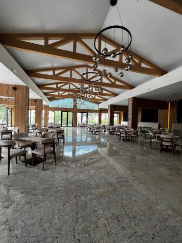a large room with tables and chairs and a chandelier at Hotel Restaurant Splendor in Buşteni