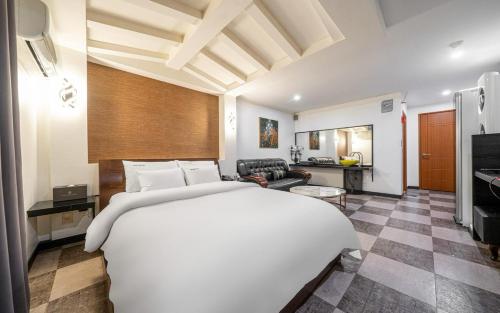 a bedroom with a large bed and a living room at Hotel The Fine in Uijeongbu