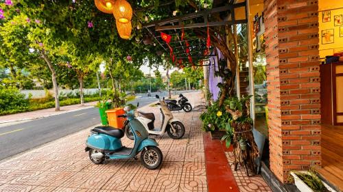 two scooters parked on a sidewalk next to a building at Q Song Chi Côn Đảo Hotel in Con Dao
