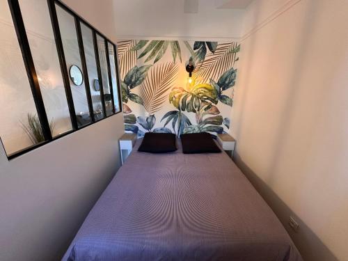 a bed in a room with two pillows on it at Appartement face mer Le Croisic , piscine privée et plage in Le Croisic