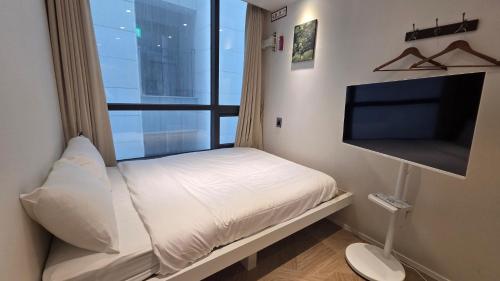 a small bedroom with a bed and a large window at Mumum Jongno in Seoul