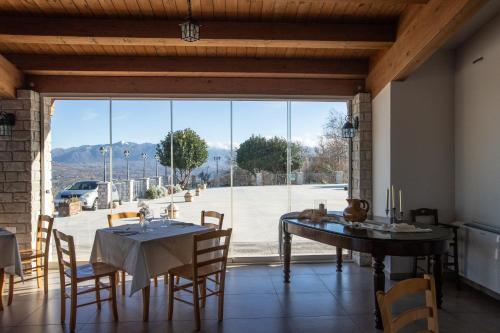 a dining room with a table and chairs and a large window at Tenuta Giave - nel cuore dell'Irpinia in Montemarano