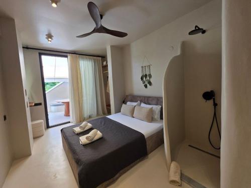 a bedroom with a bed with a ceiling fan at Vaios Luxury Apartments in Polychrono