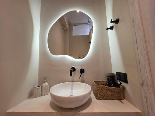 a bathroom with a white sink and a mirror at Vaios Luxury Apartments in Polychrono