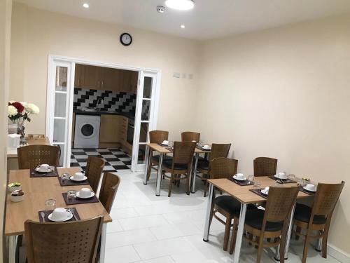 a dining room with tables and chairs and a fireplace at Woodlands Lodge Ilford in Ilford