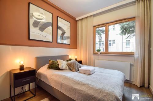 a bedroom with a bed and a window at Cavallia Garden by LookAp - parking w garażu, ogródek in Poznań