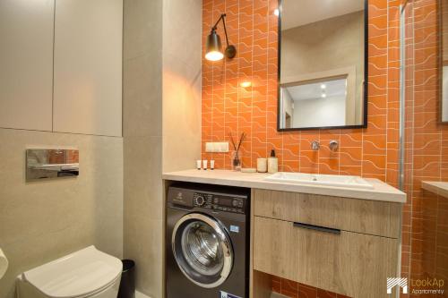 a bathroom with a washing machine and a sink at Cavallia Garden by LookAp - parking w garażu, ogródek in Poznań