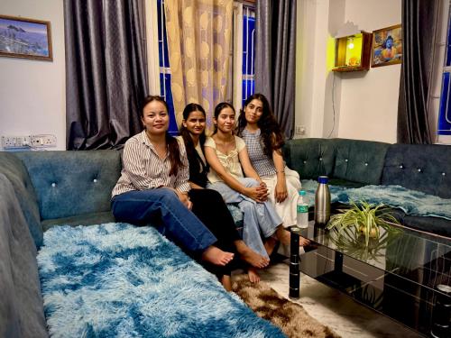a group of four girls sitting on a couch at The Basecamp Dorm in Siliguri