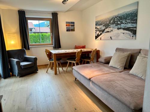a living room with a couch and a table at Ferienwohnung am Lindenweg in Brixen im Thale