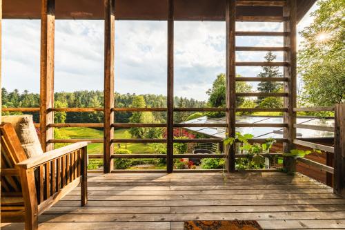 a porch with a bench and a view of the forest at Posestvo Laz - The Laz Estate in Voglarji
