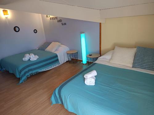 a bedroom with two beds and a blue light at MAISON BISCARROSSE LAC 6 pers in Biscarrosse