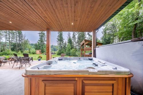 a jacuzzi tub on the patio of a house at Spa & River - Le Saint-Gabriel in Saint-Gabriel-De-Valcartier