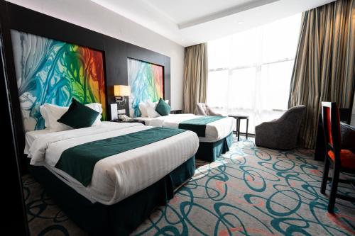 a hotel room with two beds and a large window at فندق الراحة السويسرية Swiss Repose Hotel in Jeddah