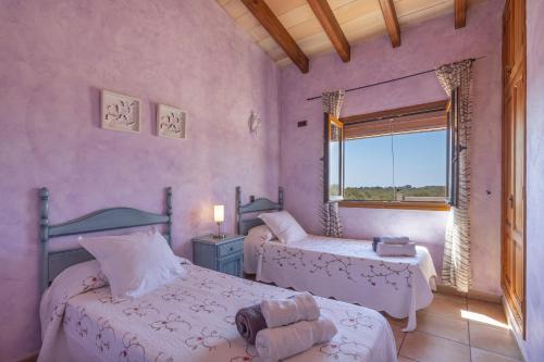 a bedroom with two beds and a window at Los tres soles in Portocolom