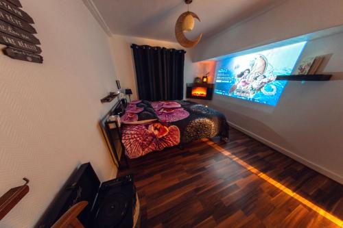 a bedroom with a bed with a large screen at Studio Cinéma -Hypercentre- Spacieux, calme et connecté in Auxerre