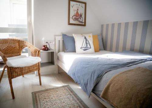 a bedroom with a bed and a chair and a window at Marina Sasino - Komfortowe Domy z Sauną i Kominkami in Sasino