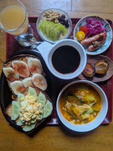 a tray with a plate of food and a drink at YAMABE BOSSA inn in Matsumoto