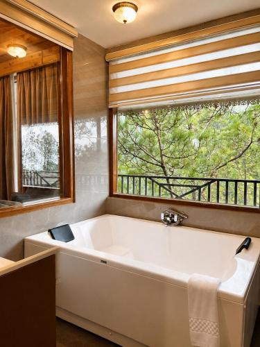 a large bath tub in a bathroom with a window at Chillaru Spa & Resort in Kasauli